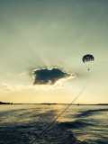 A parasail silhouette in front of a bright sunset