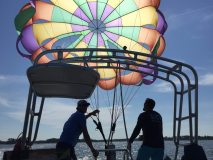 A rainbow parasail hovering above a boat