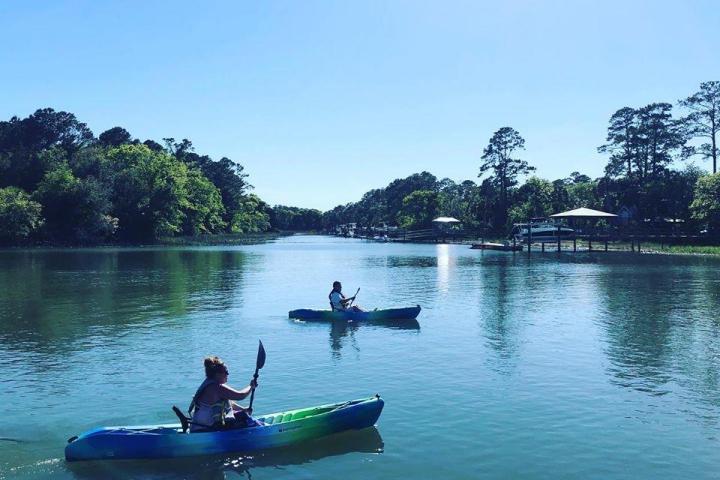 a man in a green boat on a body of water