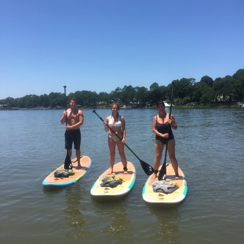 Three paddle boarders posing on the water