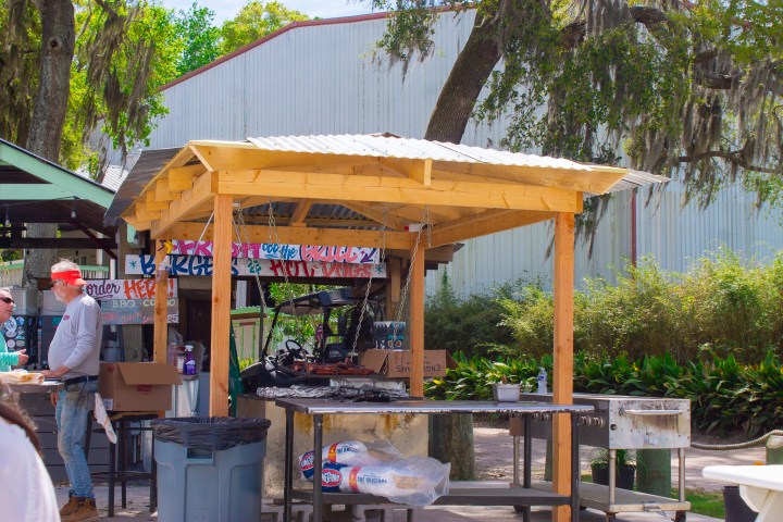 a group of people sitting at a table with an umbrella