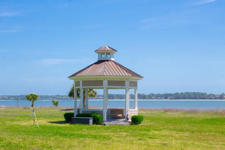 a couple of lawn chairs sitting on top of a lush green field