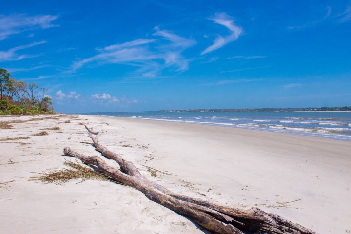 a sandy beach next to a body of water