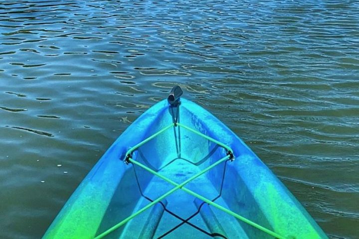 a person in a green boat on a body of water