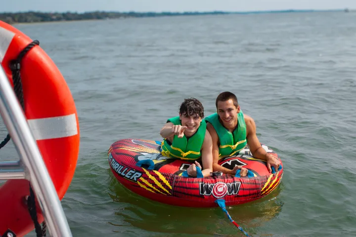 a man riding on the back of a boat in the water