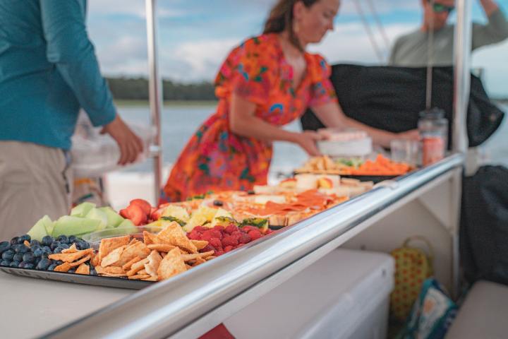 a woman standing in front of a tray of food