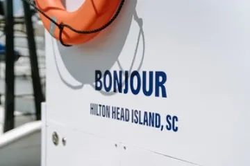 Life ring on boat with 'Bonjour Hilton Head Island, SC' text visible.